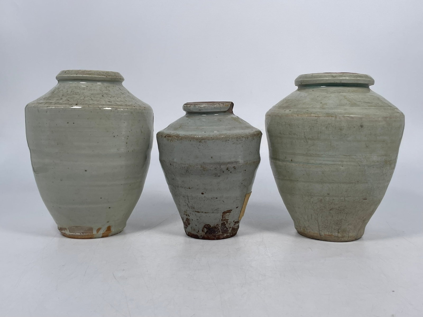 A Group of Three Chinese Celadon-Glazed Jars, Ming Dynasty: The tallest measures 7 in. high, 5.1/2 in. wide. Provenance: From the renowned John Allen Tabor Collection. John Tabor (1917?1991), a U.S. Foreign Service officer with USAID, worked throughout Asia in