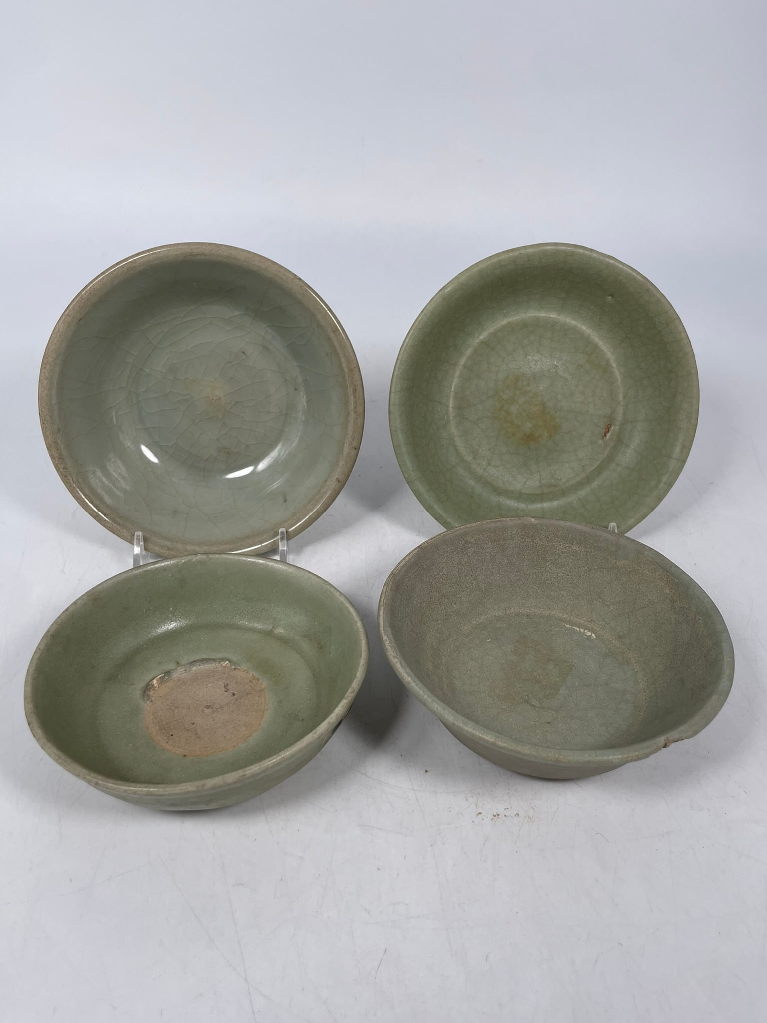 A Group of Four Chinese Celadon-Glazed Porcelain Bowls, Song Dynasty: The tallest bowl measures 2 in. high, 5.3/4 in. diam. Provenance: From the renowned John Allen Tabor Collection. John Tabor (1917?1991), a U.S. Foreign Service officer with USAID, worked throughout As