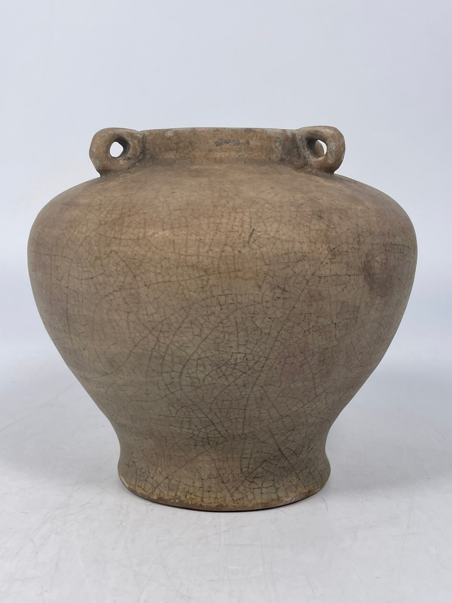 A Chinese Celadon-Glazed Jar, Ming Dynasty: 6 in. high, 7 in. wide. Provenance: From the renowned John Allen Tabor Collection. John Tabor (1917?1991), a U.S. Foreign Service officer with USAID, worked throughout Asia in the 1960s and assembled