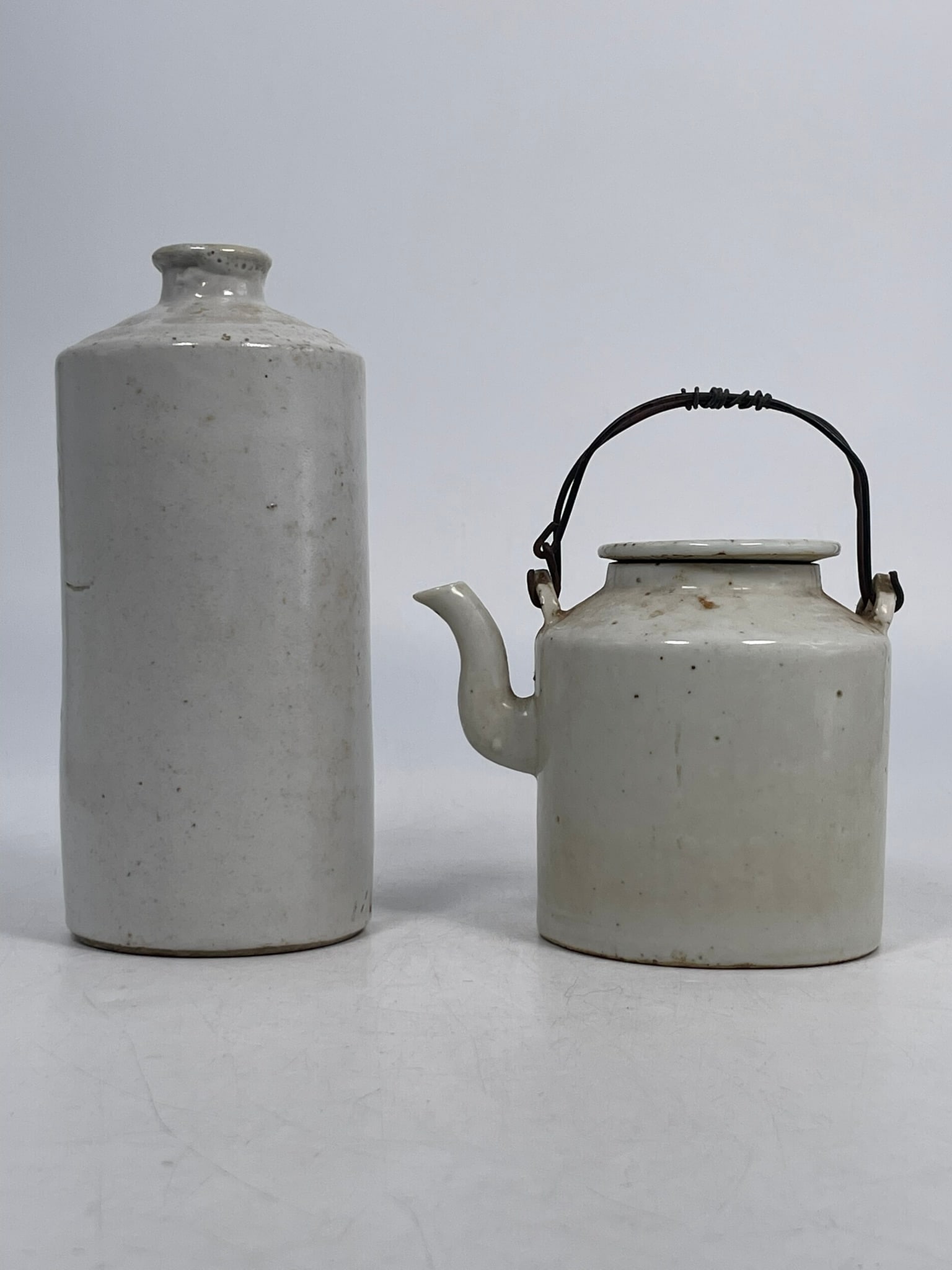 Two Chinese White-Glazed Porcelain Ware, Ming Dynasty: The teapot and cover measures 5.3/4 in. high, 5 in. wide; the vase measures 7.1/8 in. high, 3.1/8 in. wide. A Private Collection of a Retiring University Professor.
