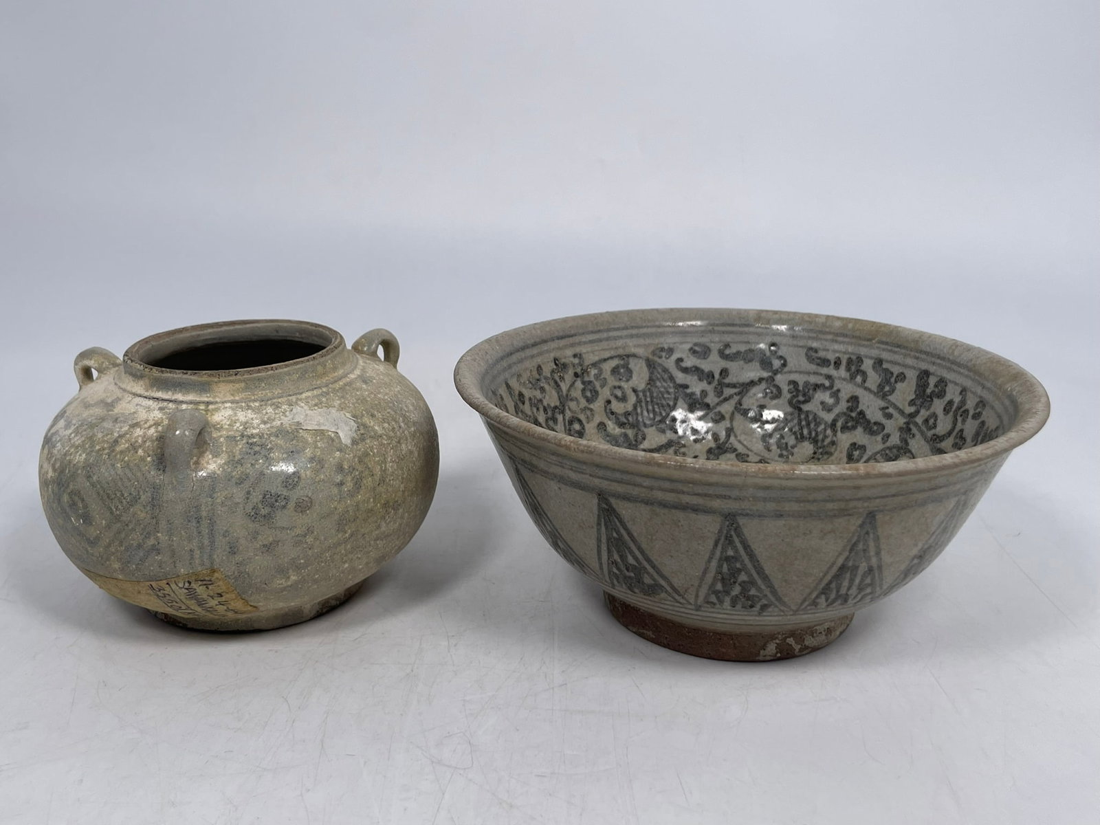 Two Thai Sawankhalok Blue and White Porcelain Ware: Comprising a bowl, 3 in. high, 6.3/4 in. diam.; and a jar, 3 in. high, 4.3/4 in. wide. Provenance: From the renowned John Allen Tabor Collection. John Tabor (1917?1991), a U.S. Foreign Service