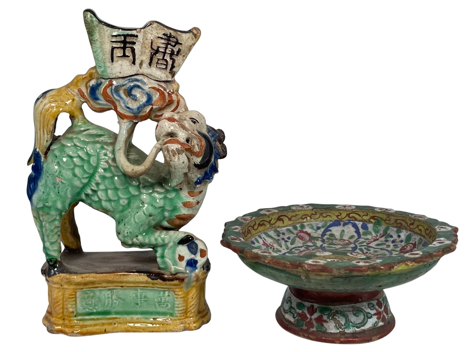 Two Chinese Painted Pottery Objects: Comprising a sancai glazed Buddhist lion, 8 in. high, 5 in. wide; a painted stem dish, 2.3/4 in. high, 6 in. diam. A Private Collection of a Retiring University Professor.