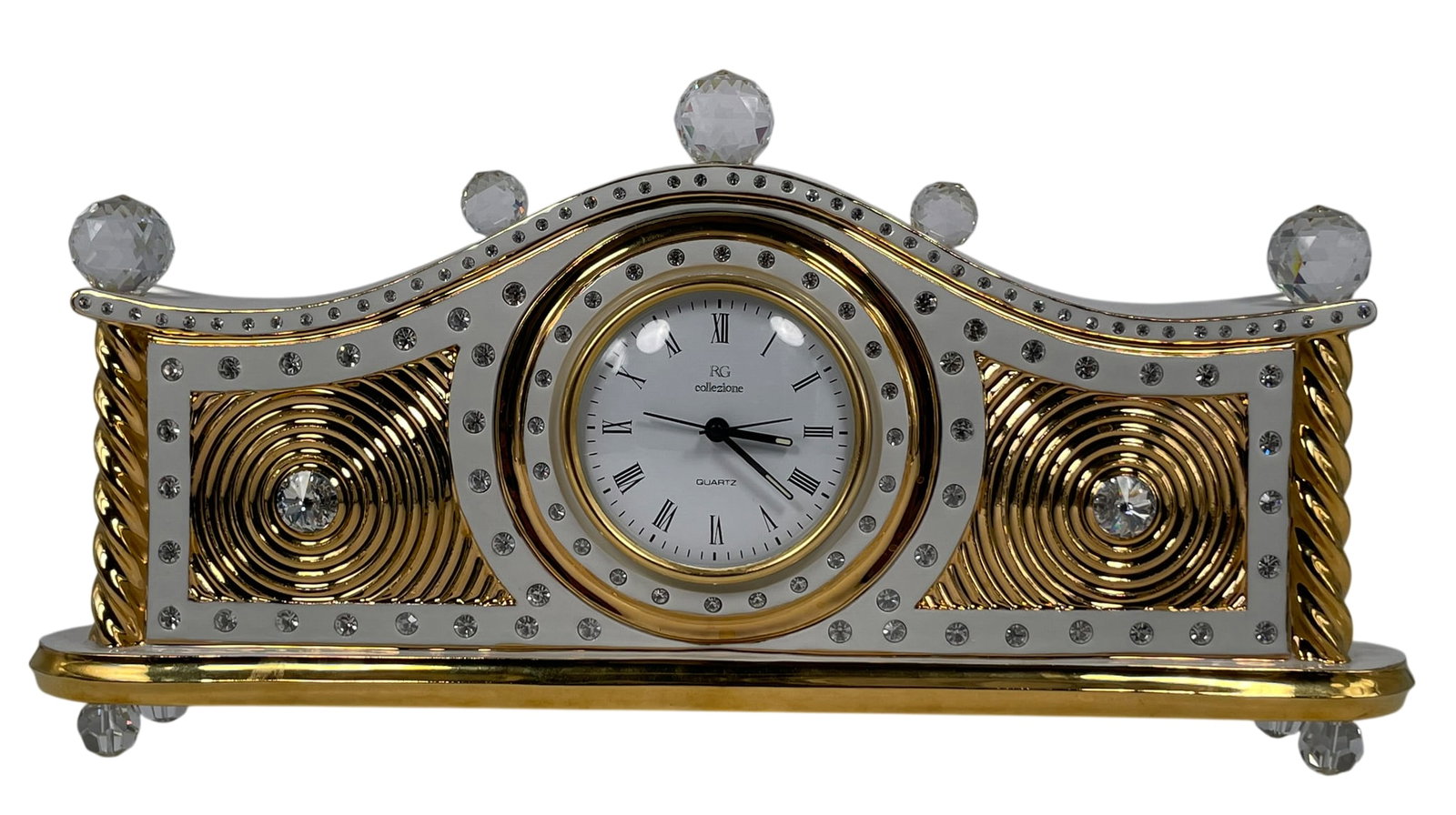 A Vintage Italian Collezione R.G. Gilt-Decorated Capodimonte Porcelain Table Clock: Decorated with Swarovski crystal applications, with a Capodimonte mark and a Collezione R.G. stamp to the back. 8 in. high, 16 in. wide.