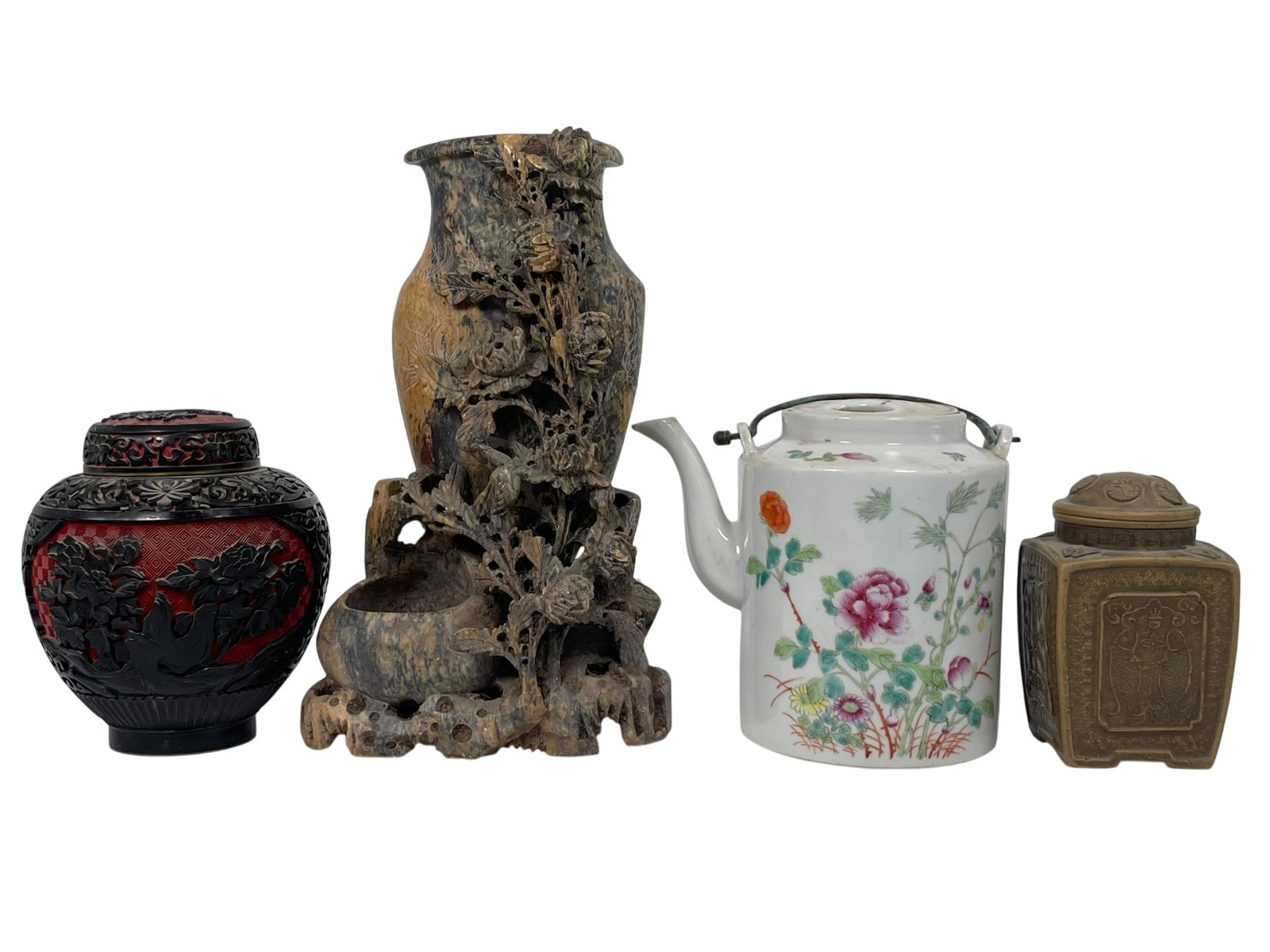 A Group of Four Chinese Porcelain/Lacquer/Soapstone Objects: Comprising a famille rose teapot and cover, 6.1/2 in. high, 7.1/4 in. wide; a pottery tea caddy and cover, studio mark to the underside, 5.1/4 in. high, 3.1/4 in. square; a small lacquer jar and cover