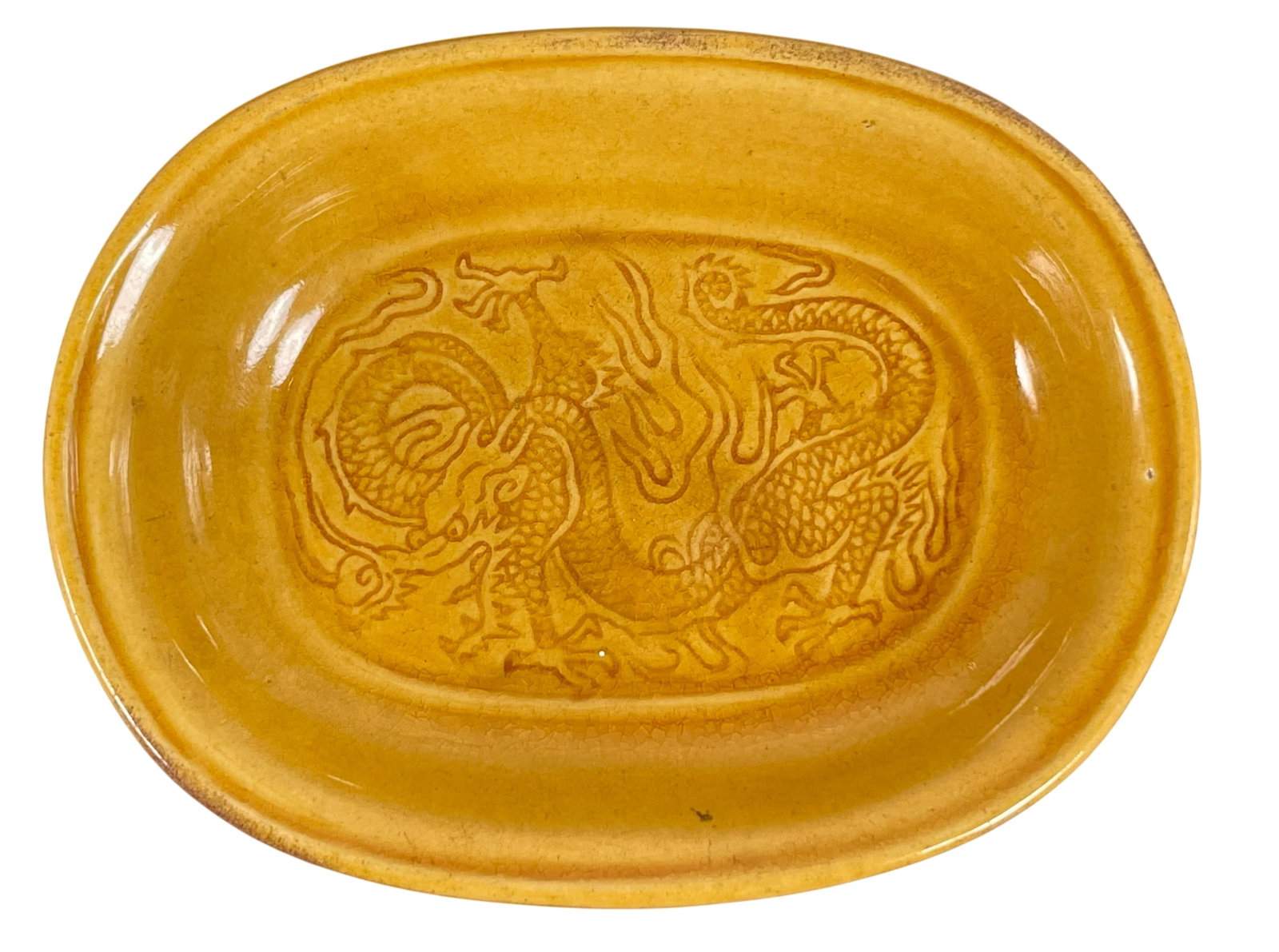 A Chinese Yellow-Glazed 'Dragon' Saucer: 4.3/8 in. long, 3.3/8 in. wide.