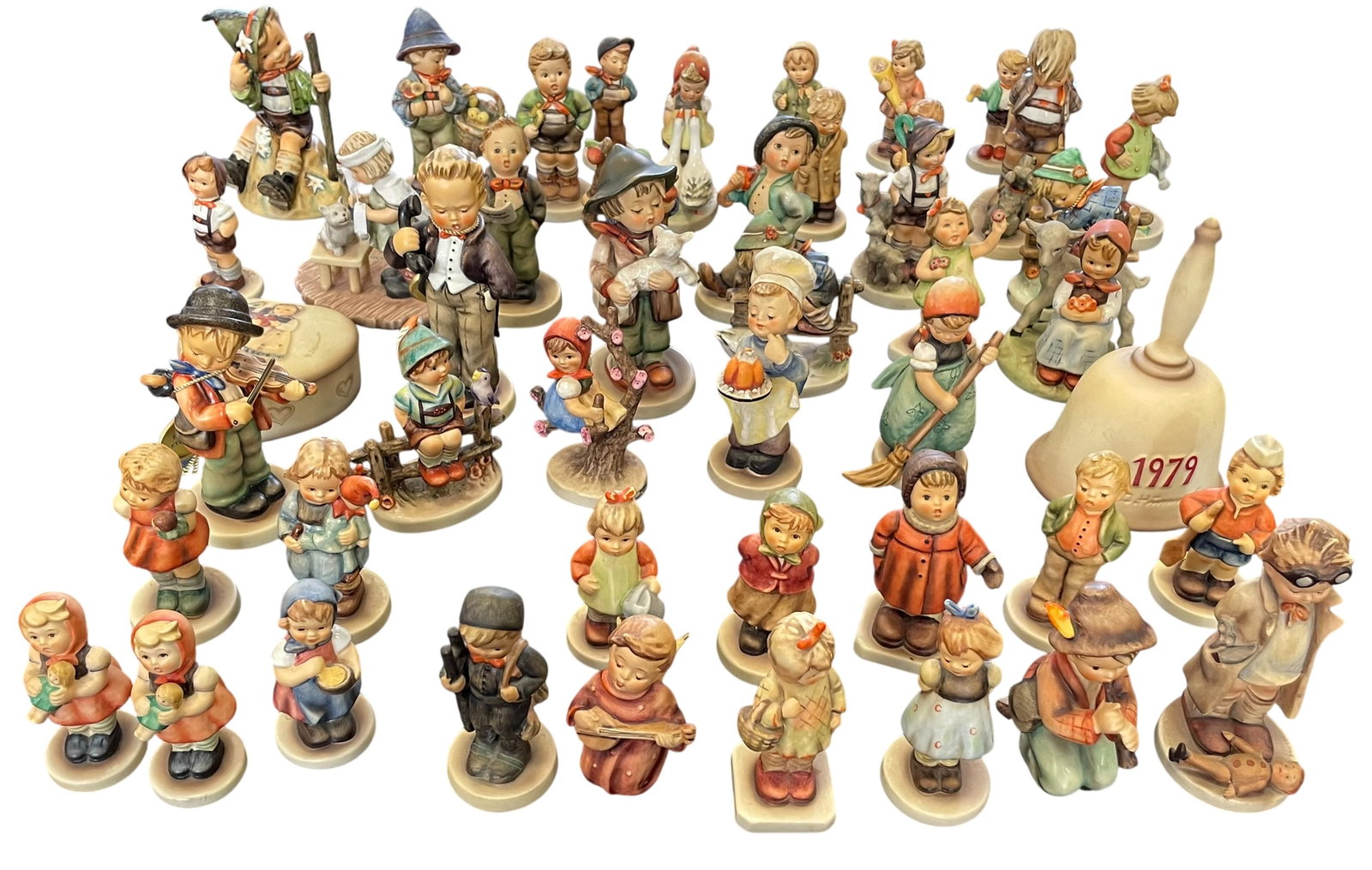 A Large Collection of Forty-Eight Vintage German M.J. Hummel (Goebel) Porcelain Figurines: Depicting children in various charming, classic poses. All marked with traditional Goebel trademarks on the bases. The tallest bell measures 6.1/8 in. high, 4 in. wide; the shortest figurine measures 