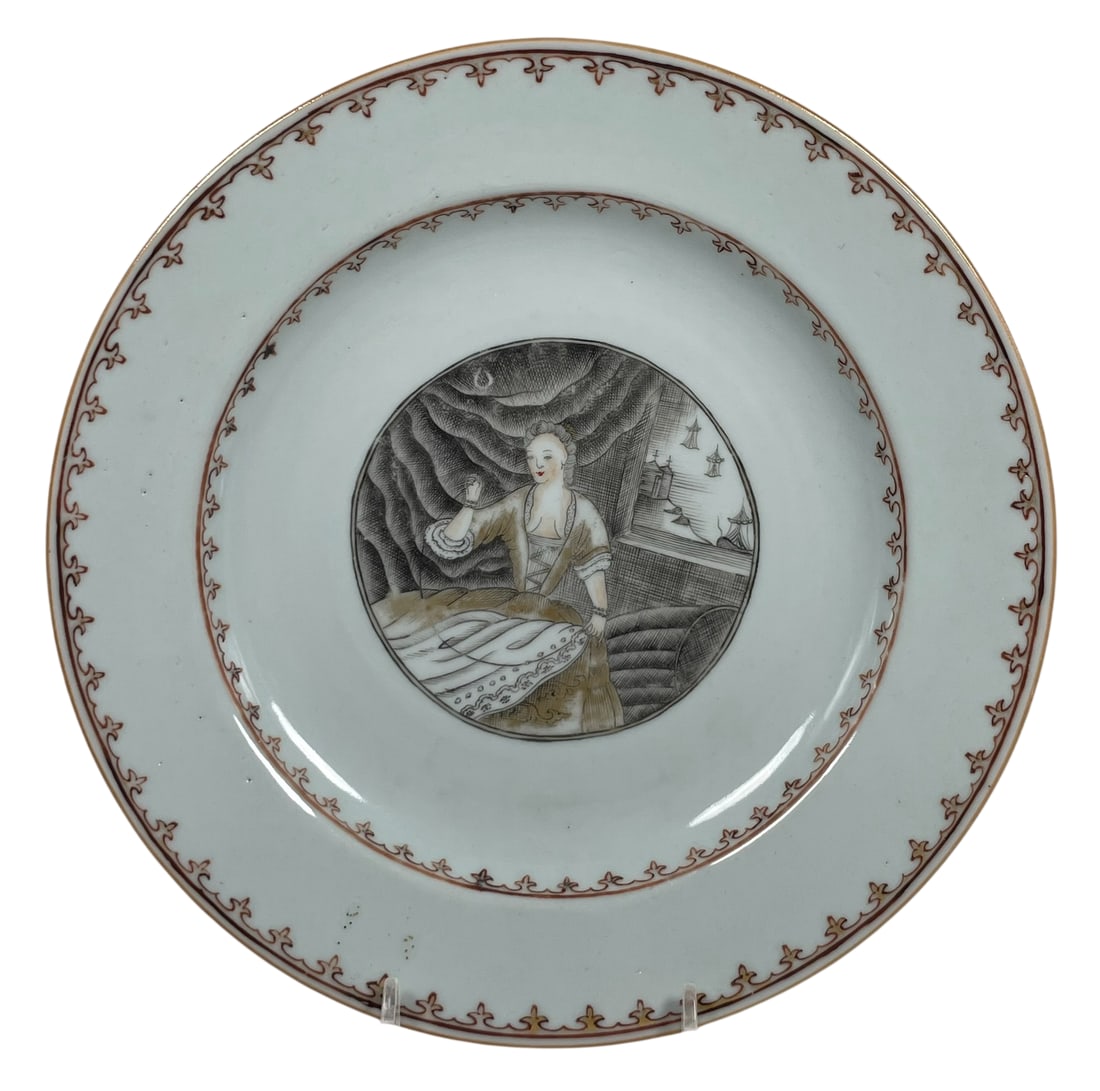 A Chinese Export Grisaille and Gilt-Decorated European Subject Dish, Qing Dynasty, 18th Century: Seamstress', depicting a lady seated in an interior before a window, with a view of sailing boats and turreted buildings beyond. 8.7/8 in. diam.