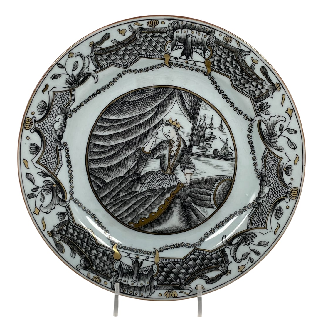A Chinese Export Grisaille and Gilt-Decorated European Subject Dish, Qing Dynasty, 18th Century: Seamstress', depicting a lady seated in an interior before a window, with a view of sailing boats and turreted buildings beyond. 8.7/8 in. diam.