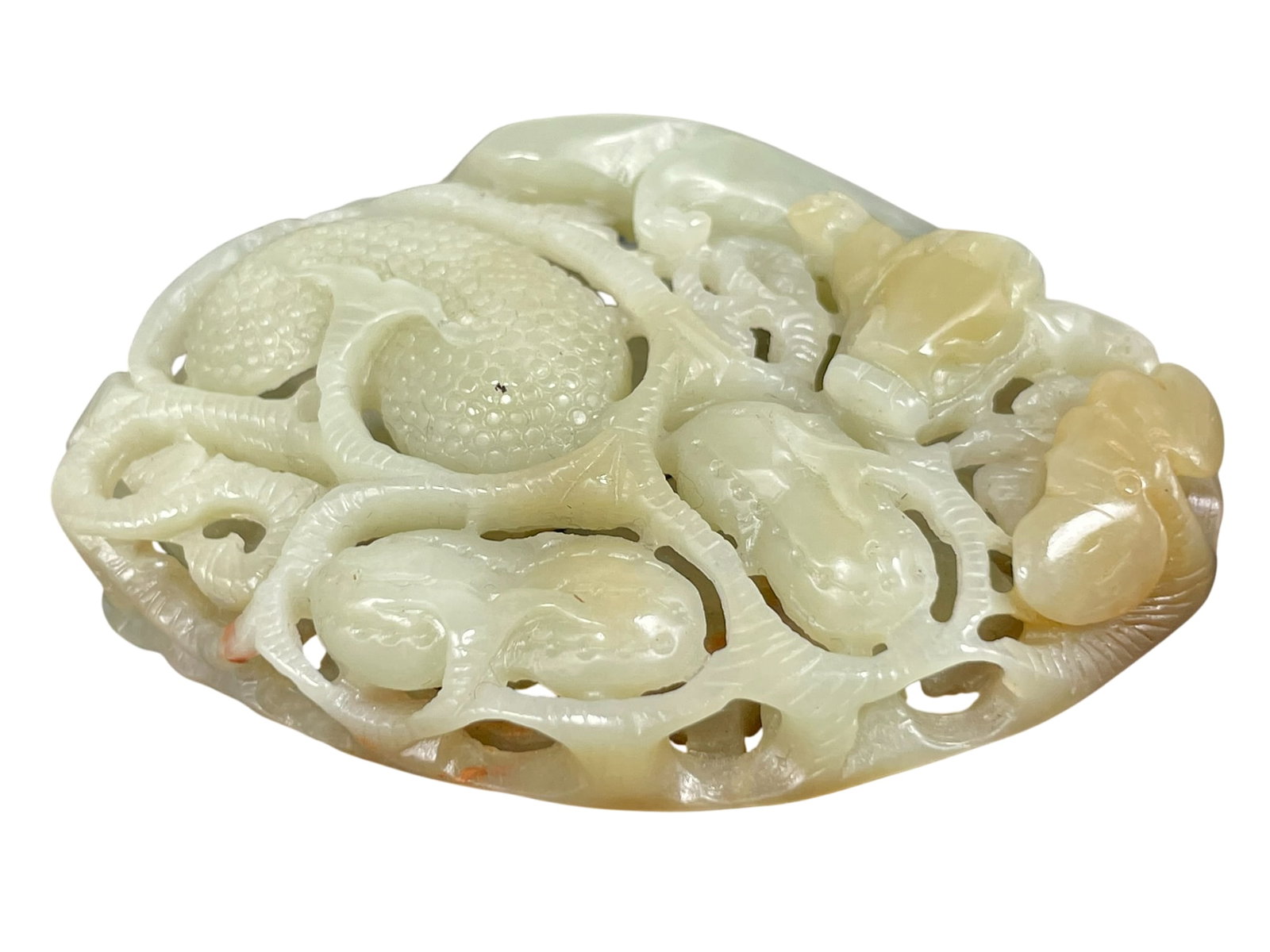 A Chinese Carved and Reticulated Celadon Jade Pendant: 2.7/8 in. long, 2.1/8 in. wide.