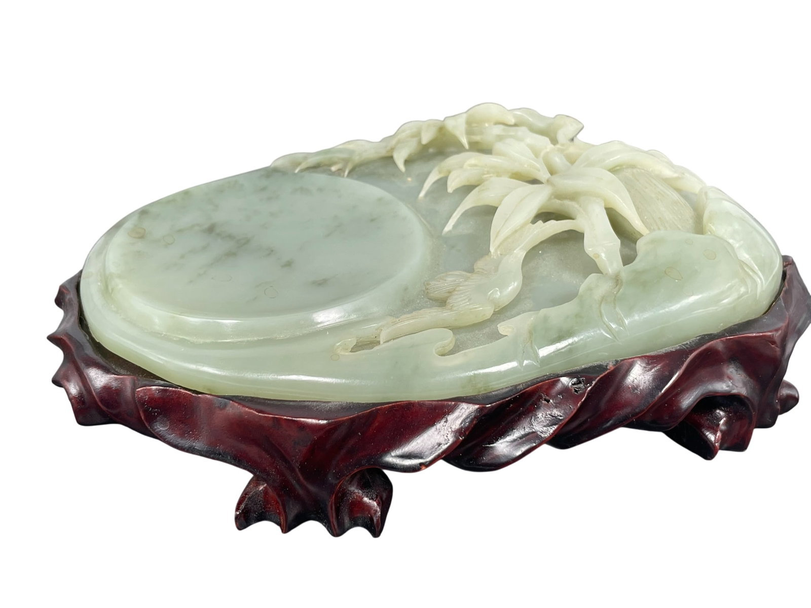 A Chinese Carved Celadon-Jade Inkwell: With a wood stand. The inkwell measures 7.1/8 in. long, 5.1/4 in. wide.