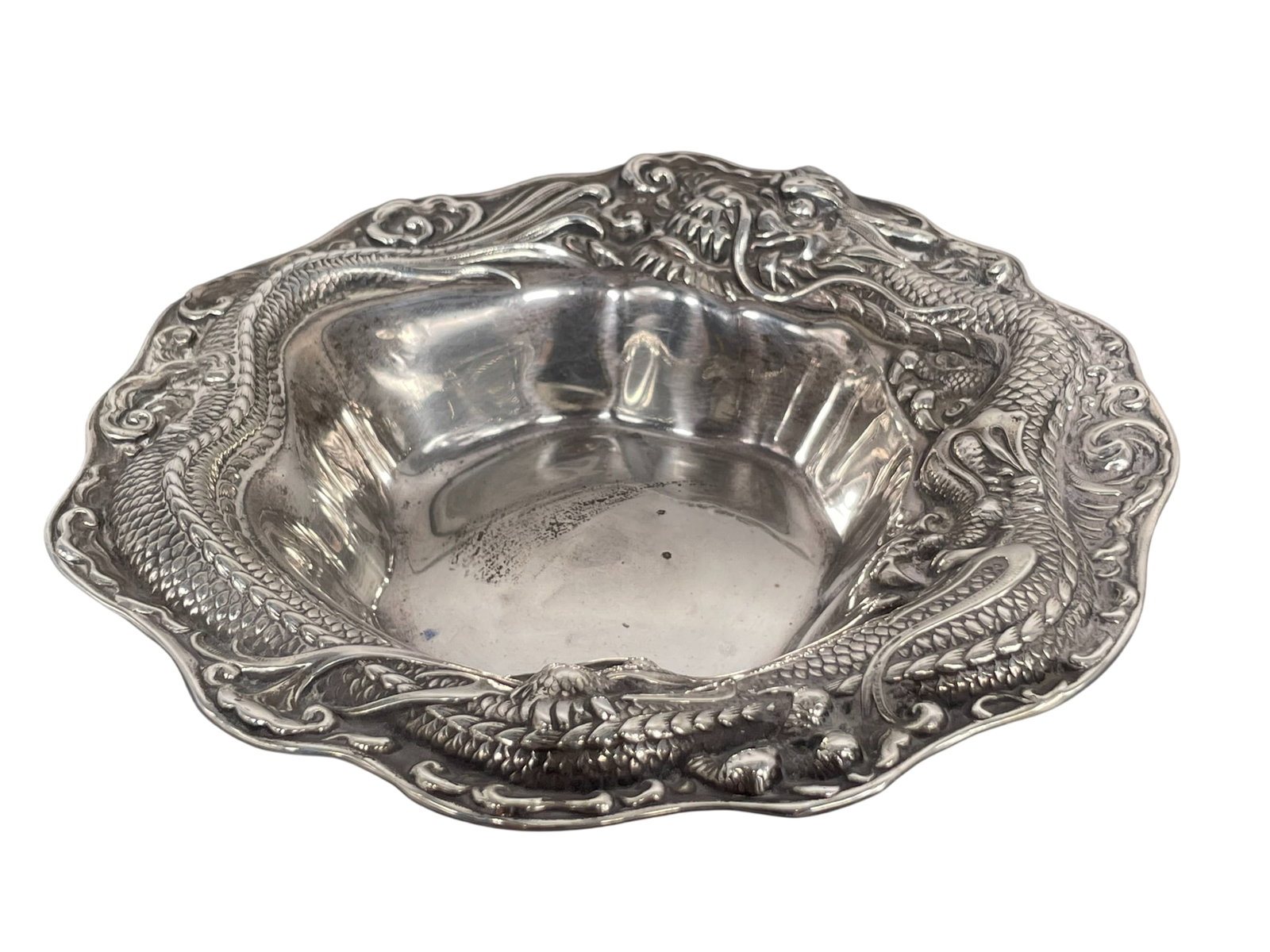 An Antique Meriden Britannia Sterling Silver Candy Bowl: A Meriden Britannia Company (later the International Silver Co.) mark (eagle mark within wreath, M), and '532' en verso. Features an ornate high-relief dragon motif wrapping around the rim in the styl