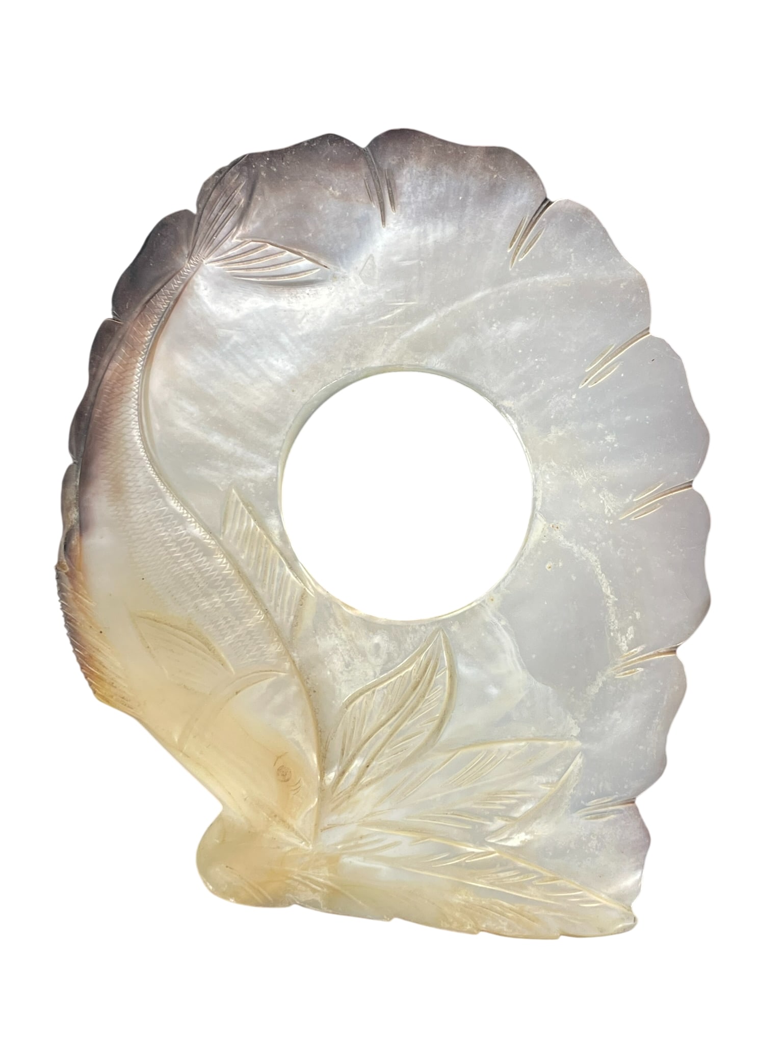 A Handcrafted Carved Mother-of-Pearl Shell Decorative Disk: Featuring floral and leaf motifs with a central hole. 6.1/2 in. long, 5.1/2 in. wide.