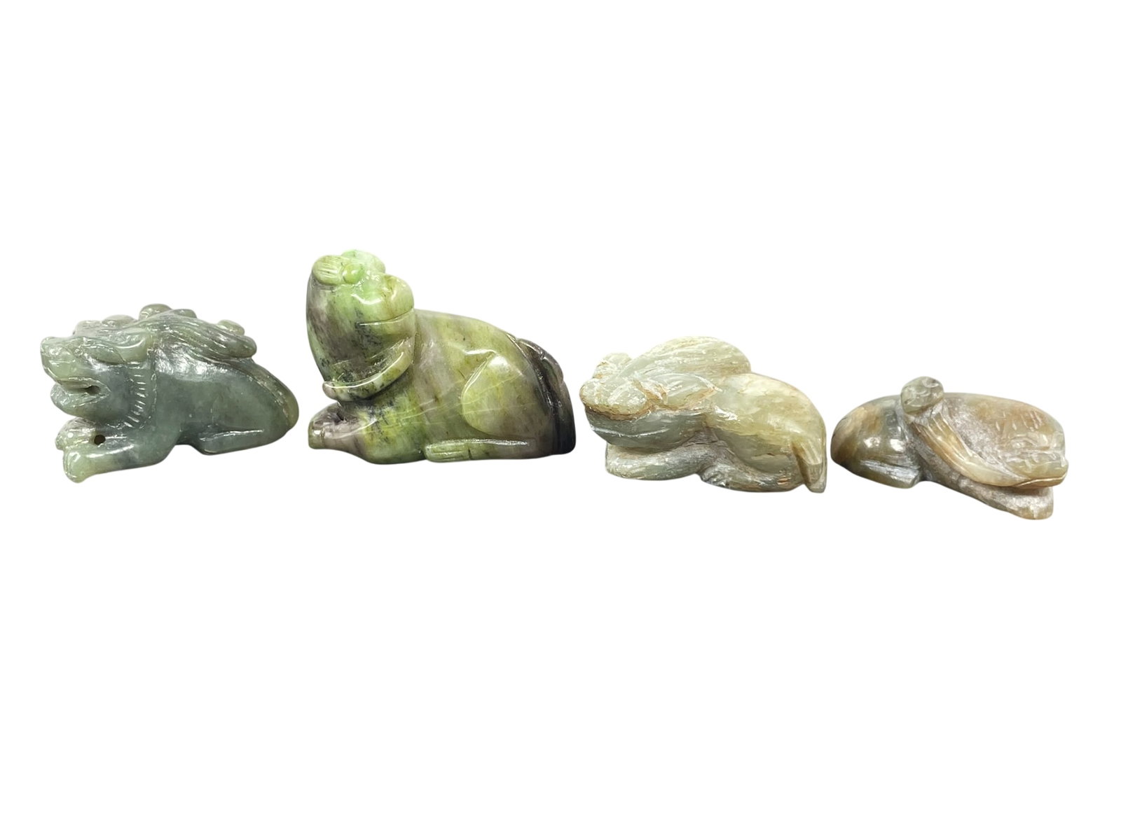 A Group of Four Carved Jade Mythical Animals: The tallest measures 1.3/4 in. high, 2.1/8 in. wide.
