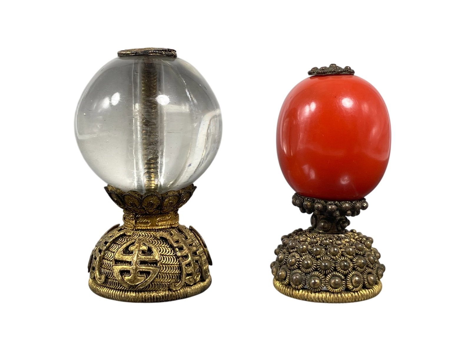 Two Hat Finials: Comprising a crystal hat finial, 2.1/4 in. high, 1.3/8 in. wide; and a coral hat finial, 2.1/8 in. high, 1 in. wide.