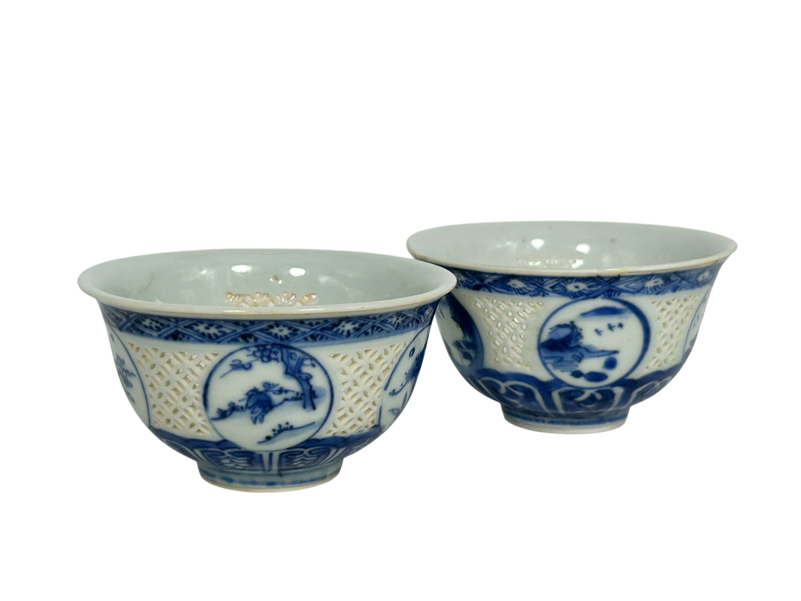 Bonhams Skinner Boston's Provenance: A Pair of Chinese Blue and White Reticulated 'Rice-Pattern' 'Me: Of upturned bell form, the sides decorated with five roundels enclosing landscape and floral designs, reserved against an openwork ground between two patterned bands, the mouth rim applied with two pa