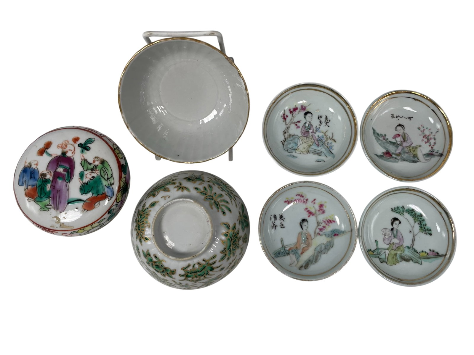 A Group of Seven Chinese Porcelain Ware: Comprising a famille verte circular box and cover, 1.5/8 in. high, 3.5/8 in. diam.; four famille rose 'lady' saucers, approximately 1.1/4 in. high, 3.1/4 in. diam. each; a pair of gilt and green