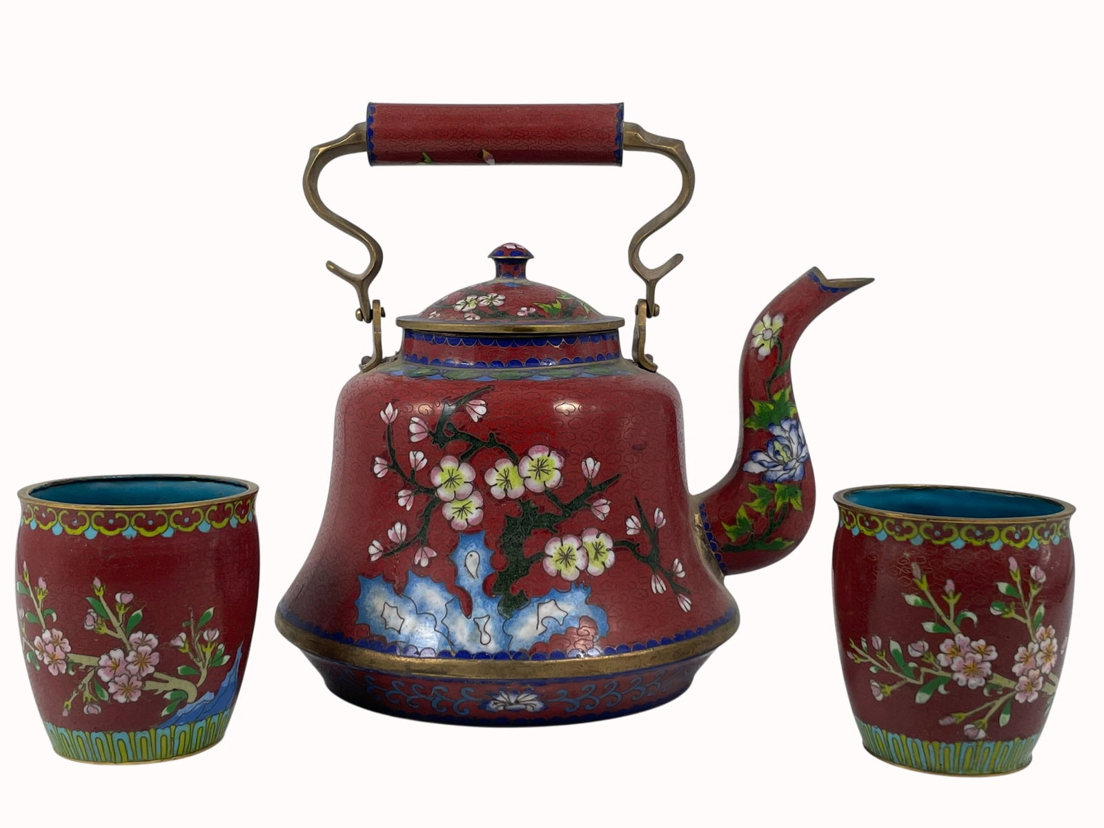 A Set of Three Chinese Cloisonne Enamel Teapot and Tea Cups: The teapot measures 8.1/2 in. high, 8.1/2 in. wide; the tea cups measures 3.1/4 in. high, 3 in. diam. each.