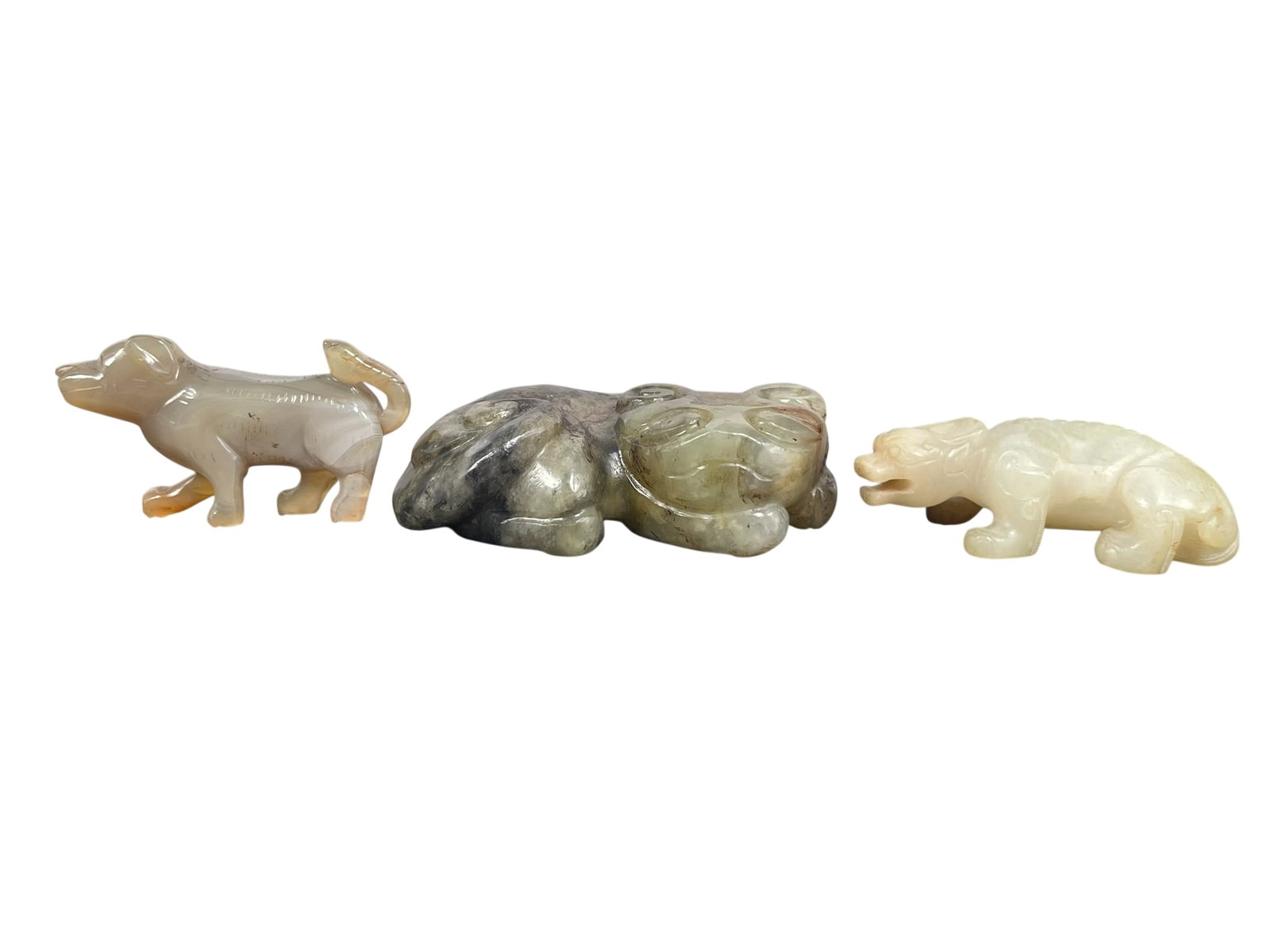 A Group of Three Chinese Jade Carving of Mythical Animals: The largest measures 1.1/4 in. high, 4 in. wide.