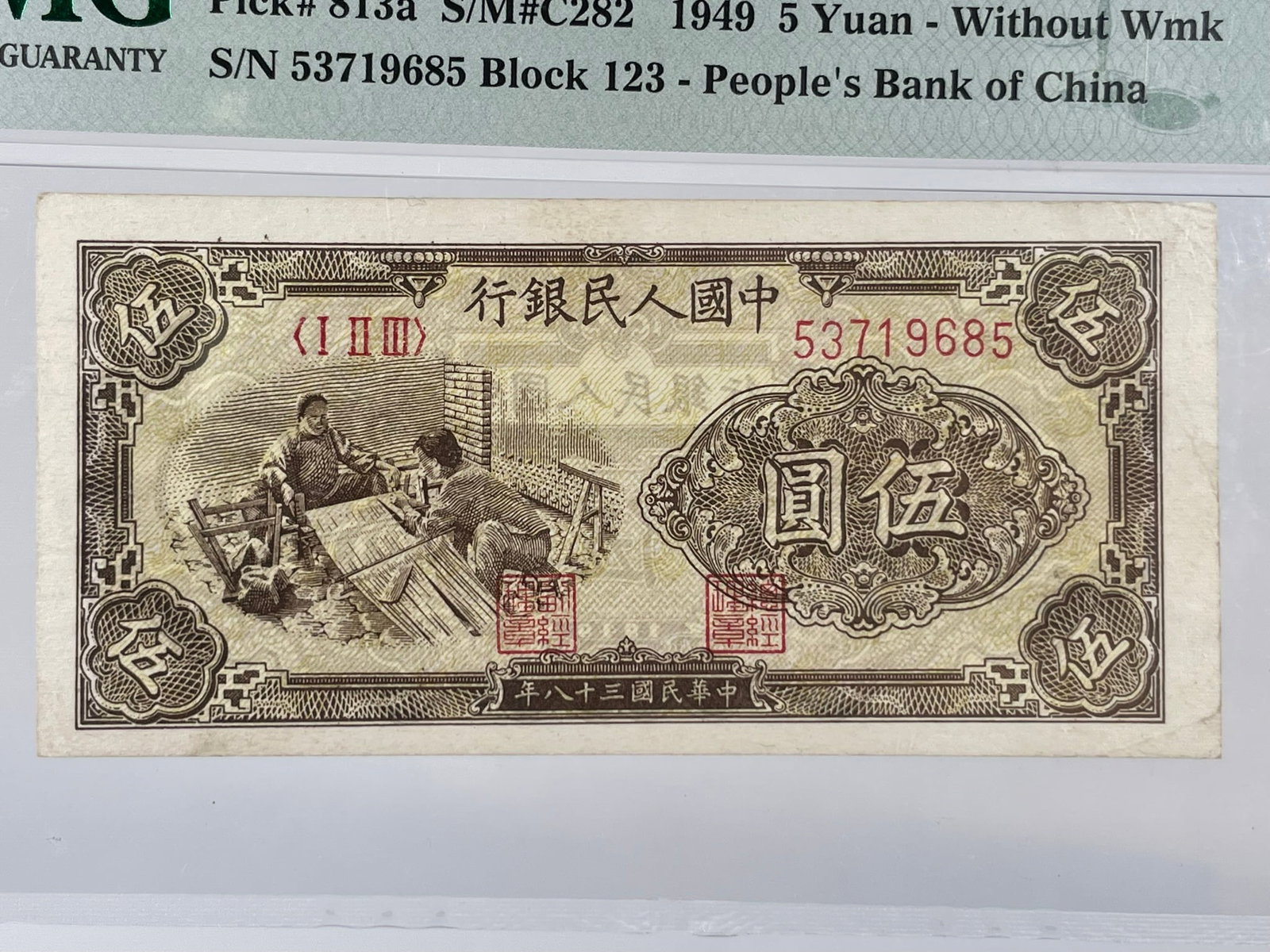 A Chinese 5 Yuan Banknote, 1949, PMG Cover: With a Paper Money Guaranty protective plastic cover, 8 in. x 4.1/4 in. overall including the cover.