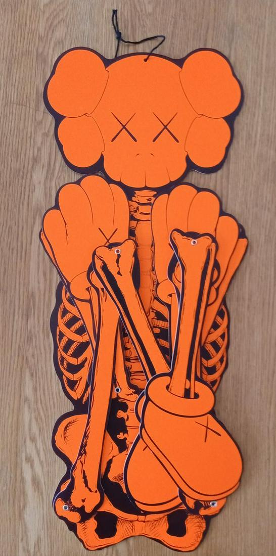 Kaws - Skeleton Board Cut out Ornament Bones (Orange), 2021 - Silkscreen on cardboard: Kaws Skeleton Board Cut out Ornament Bones, 2021 Limited edition (in orange) based on the 2007 OriginalFake Color screenprint on cardboard In its original packaging Provenance: Kaws website when put o