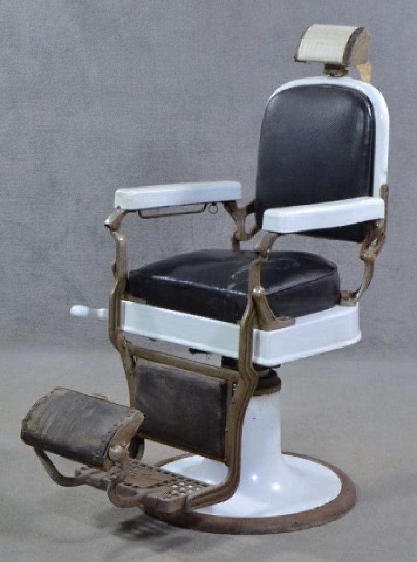 White Enamel Ceramic Barber Chair: Mid 20th century. By Koken. Black leather seat on metal white enamel base and frame. Headrest has interesting engraving and punch motif. Reclining lever on proper right side. Metal footrest marked "Ko