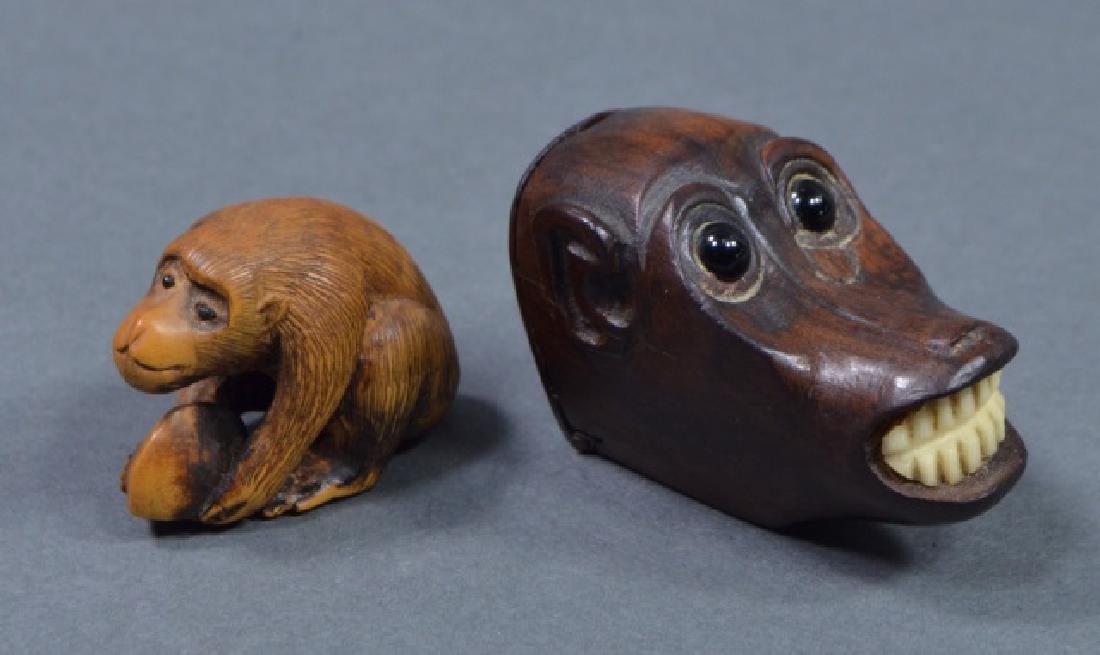 Two Antique Carved Japanese Monkey Figures: One of monkey head with inlaid, black, glass eyes. Open mouth reveals ivory teeth. Back of head opens on a hinge for storage. 1 1/4" H. x 1 3/4" W. Along with monkey figurine with black eyes, holding