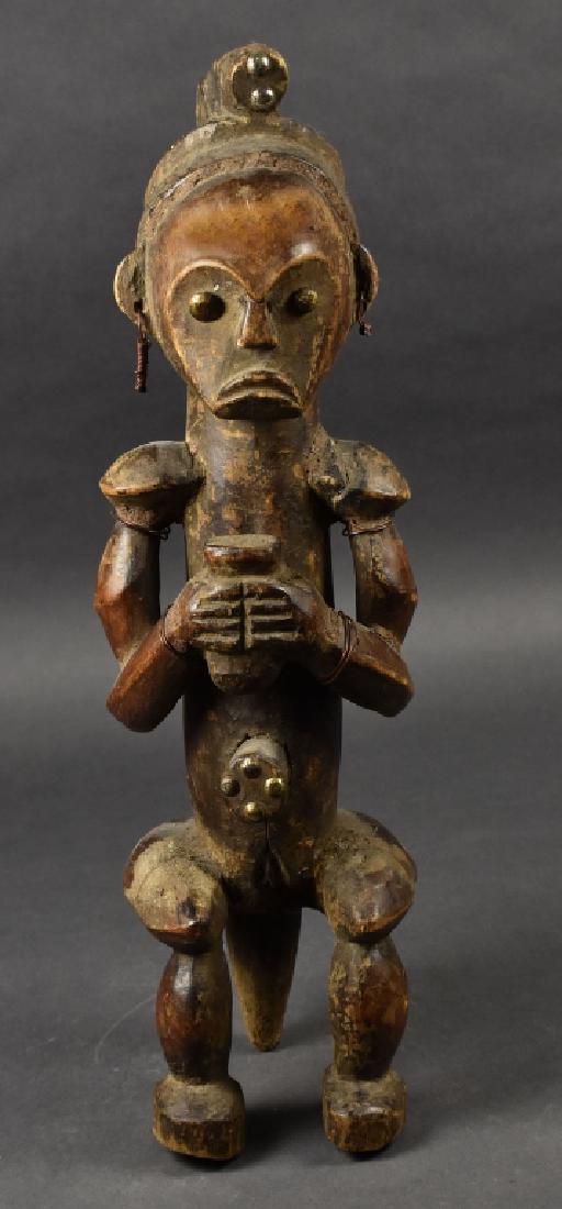 Wooden African Sculpture of Woman on Stool: Holding loaf of bread. Iron tack eyes and decoration. 19" H. Good condition.