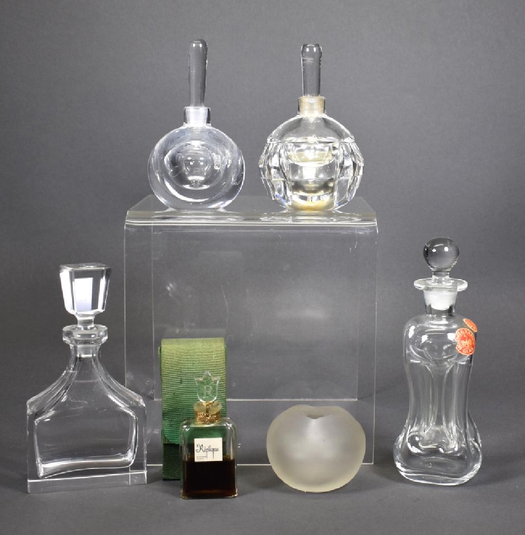 6 Vintage Crystal Perfume Bottles, 4 Signed: Two marked, "Lalique": one apple shaped, missing top and "Replique" perfume in green sleeve. One having a paper label reading, "Holmegaards Glas, Made in Denmark," 5.5"H. Two having etched, illegible