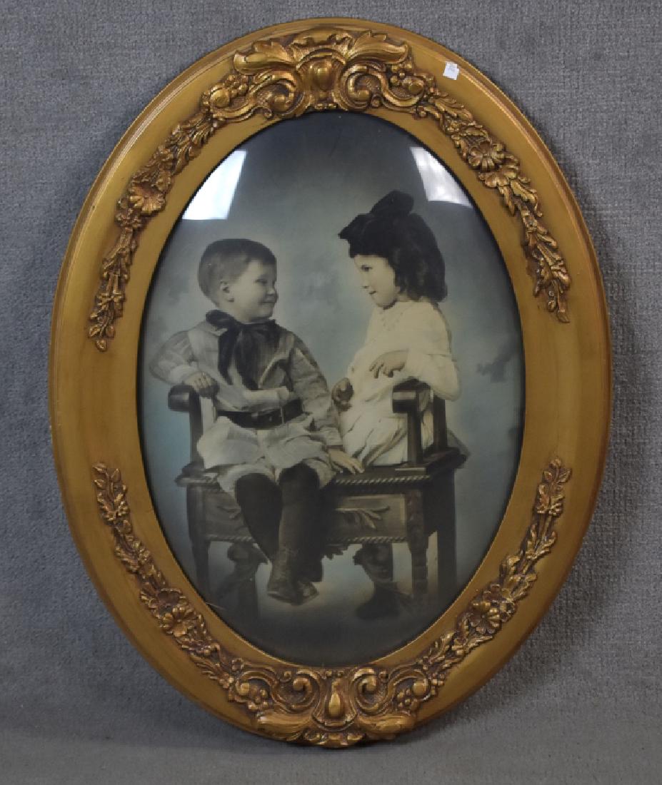 Turn of the Century Gesso Frame: With convex oval glass. Tinted photo of boy and girl. 25" x 18".