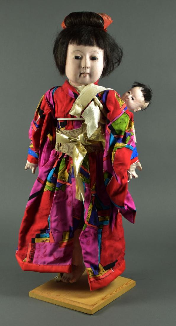 Japanese Papier Mache Ichimatsu: 24". Swivel head on shoulderplate. Jointed wrist and ankles on cloth and papier mache. Human hair wig, glass eyes. Needs some TLC. With wooden stand. Nice clothing. Baby on back.