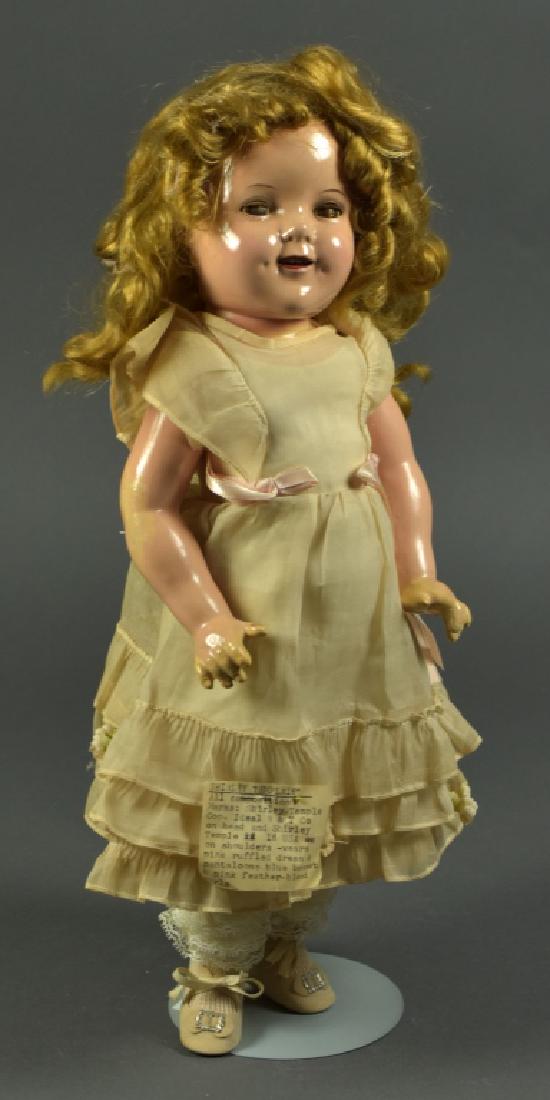 Ideal Shirley Temple in Composition: Brown sleep eyes and synthetic wig. Both head and body are marked. No crazing to composition. Dressed as "Little Miss Sunshine" but clothing is not original. 18" H.