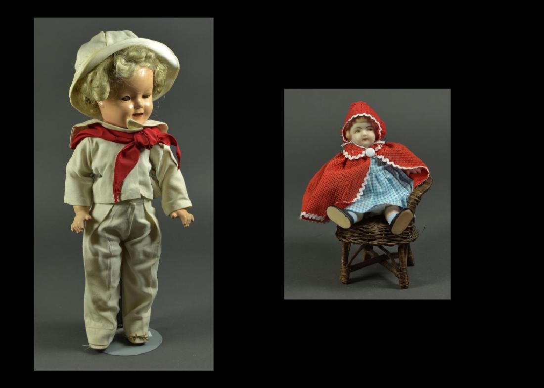18" Ideal "Shirley Temple" Composition Doll: Brown sleep eyes, blonde wig. Dressed as "Little Sailor". Composition is excellent. Along with a 7" Japanese all-bisque doll with side-glance painted eyes. Dressed as "Red Riding Hood" in wicker chair
