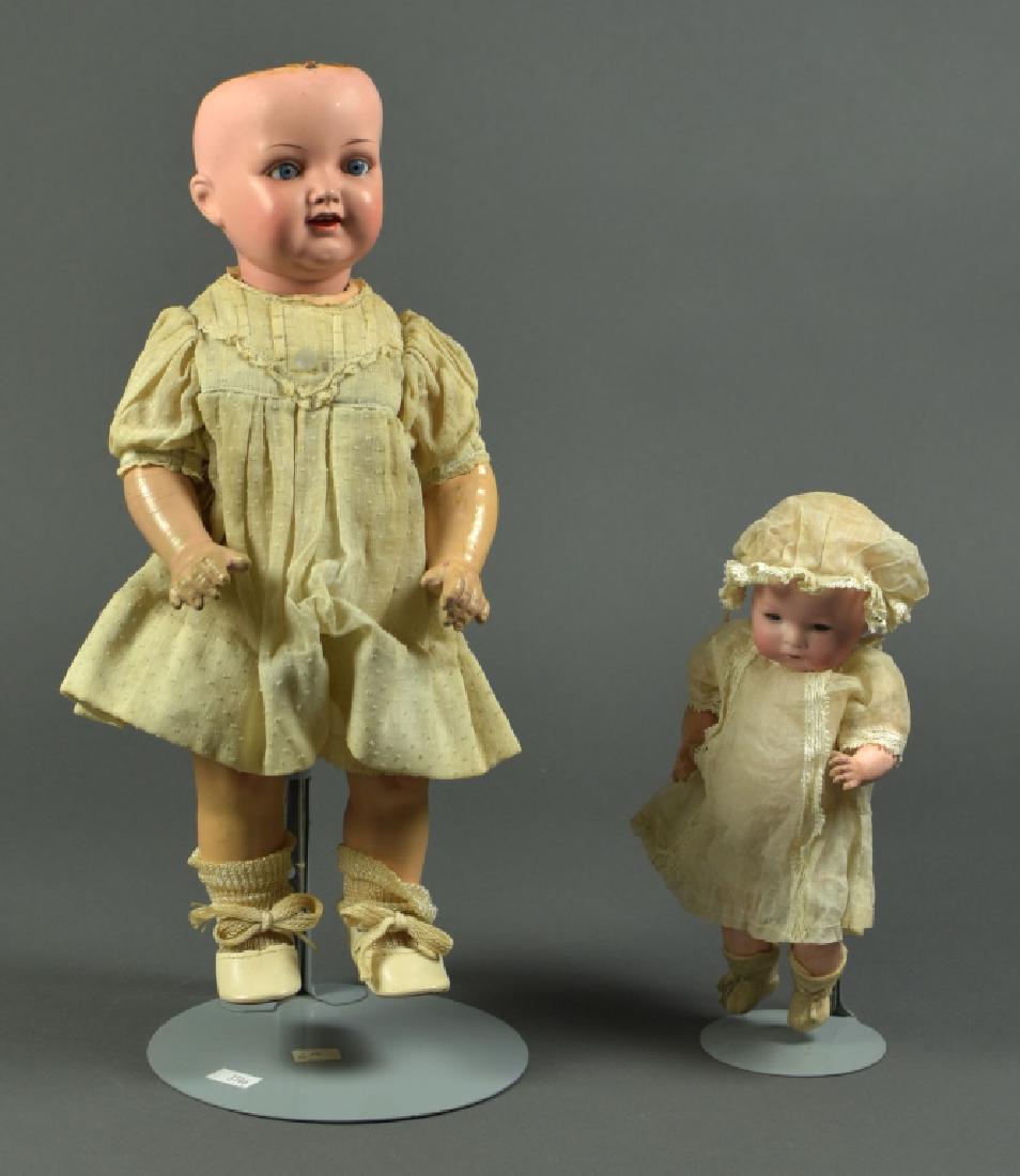 German K & R 728 Celluloid Head Girl Doll: 15". Blue sleep eyes, closed mouth, dome head with painted hair. Five piece composition baby body. Newer clothing. Also an 8" Amberg & Son flange head body. Blue set eyes, closed mouth, dome head with