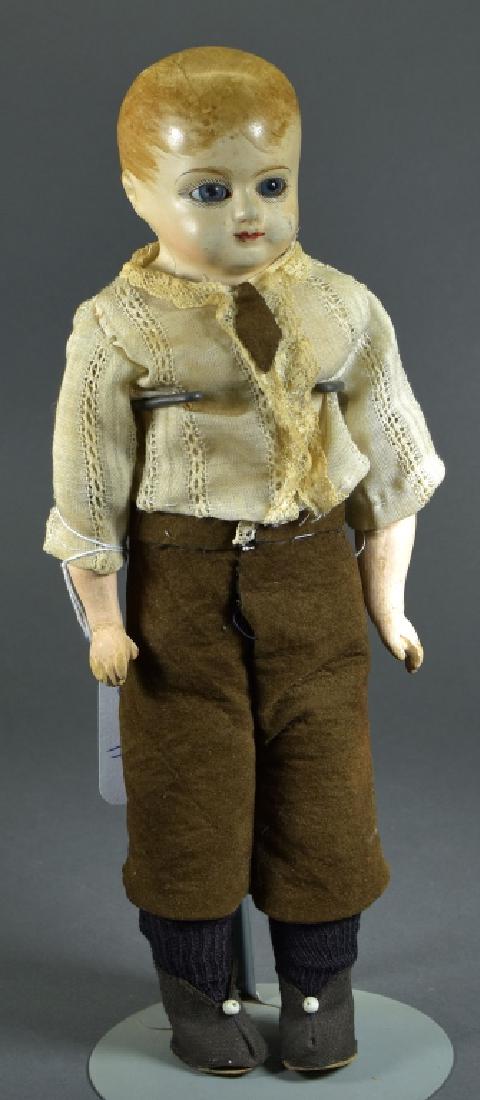 Papier Mache Boy Doll: 12 1/2". Kid body and antique clothing. Blue glass set eyes with painted hair and features. Ca. 1870.