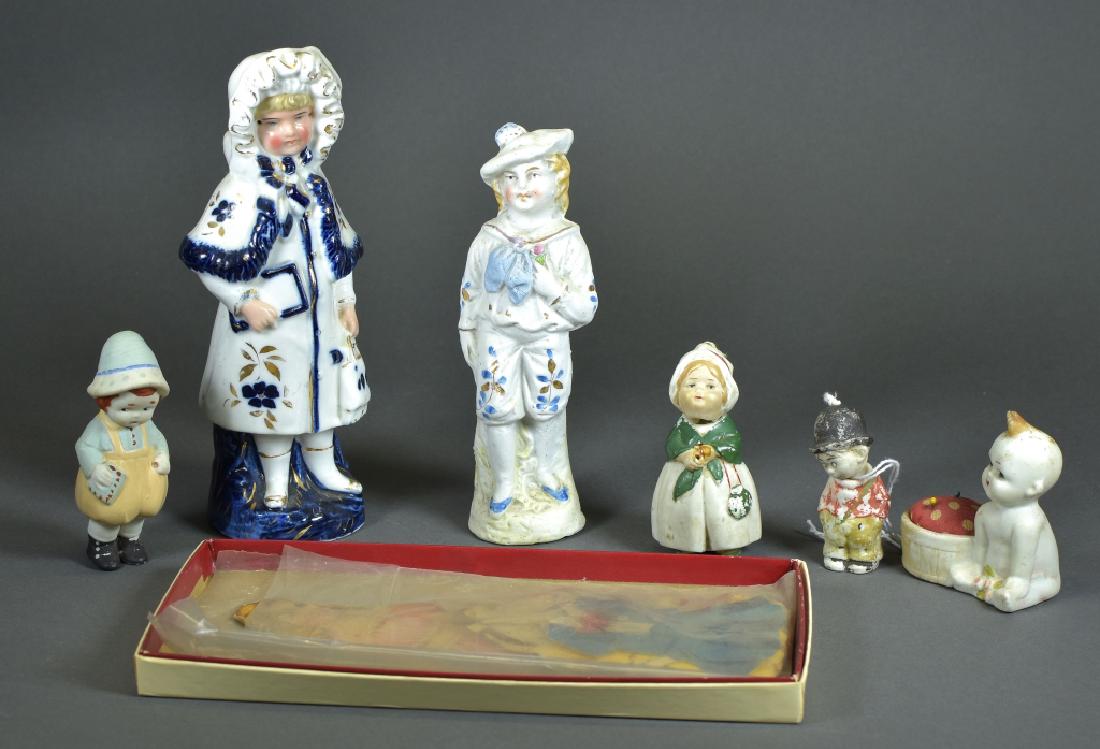 Lot of Variety of Dolls: Cut paper doll "Linda" with clothes, 7" nice glazed bisque girl figurine in winter clothes. All bisque boy dressed in short pants. Three German nodder all bisque dolls. Fat baby Made in Japan pincushi