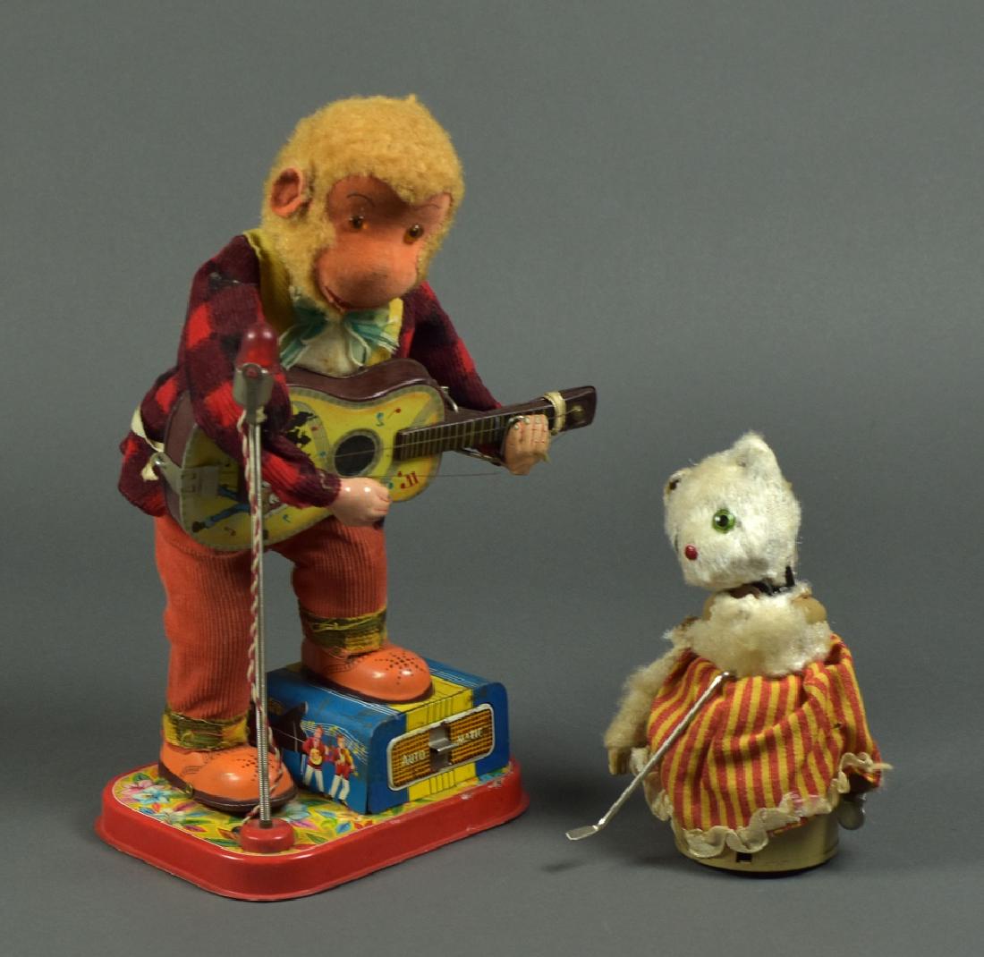 Two Tin Made in Japan Tin Toys - Monkey w/ Guitar: Includes a battery operated guitar playing monkey. Cosmetically shows wear, working condition unknown. Stands 11"H. Second is a wind up cat in poor condition.