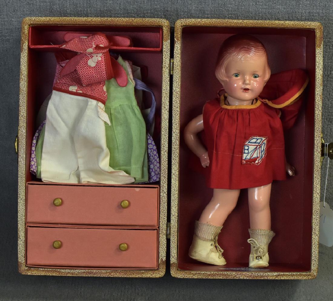 Composition Arranbee Nancy w/ Trunk & Outfits: 13 1/2". Molded hair, painted eyebrows, attached lashes are in poor condition, open mouth with teeth. Body shows crazing and head is loose on neck socket. Both arms are loose at the joints. The top of