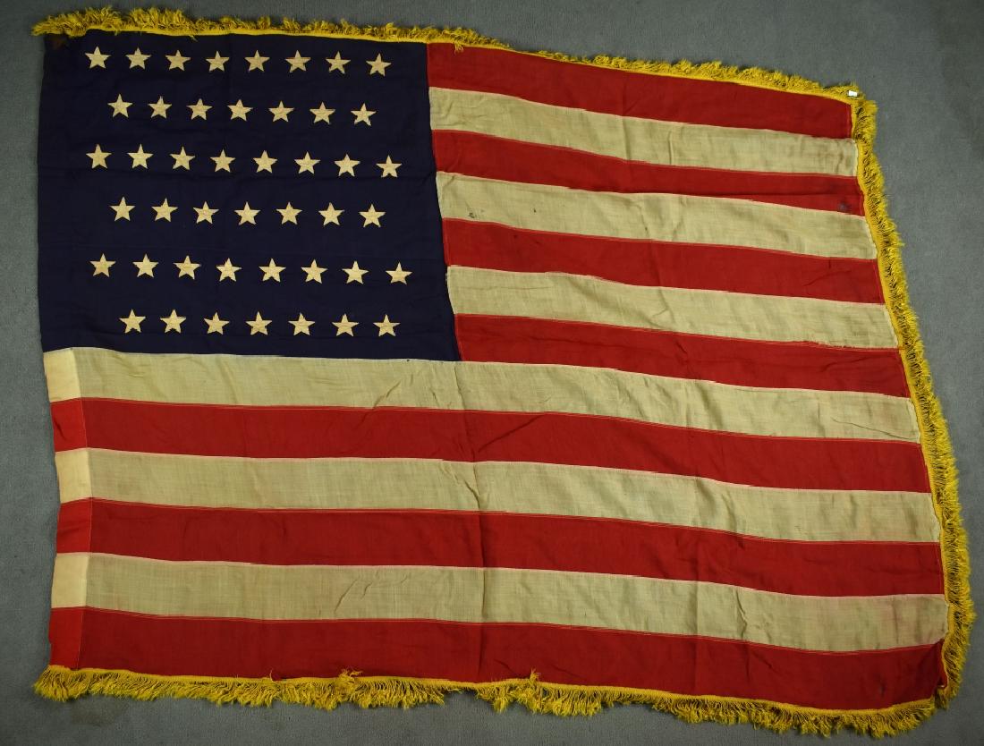 Circa 1910 45 Star Flag with Yellow Cloth Fringe 46 US: 45 US flag with yellow fringe. Has one leather tab on upper edge of hoist side. Lower tab is missing. Damage to lower hoist edge and multiple small holes through out the blue field and on the stripes.