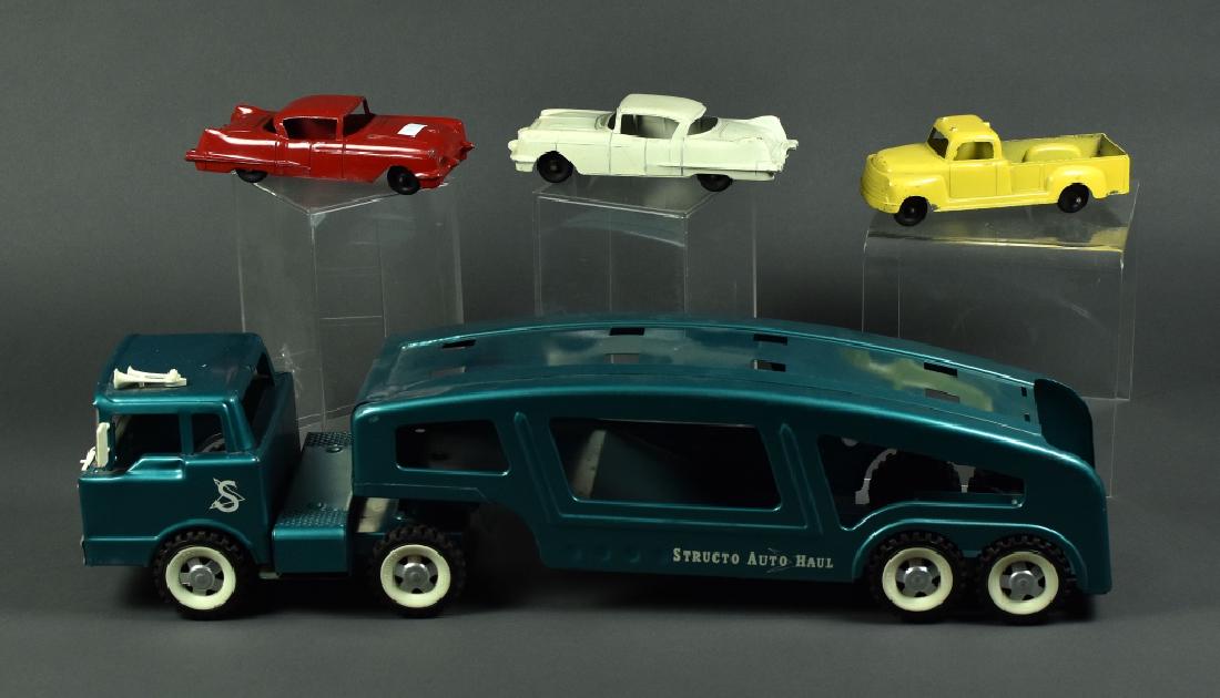 Structo Auto Hauler with Three Vehicles Teal Structo: Teal Structo Auto Hauler with two cars and truck. Truck cab still has mirrors, wipers, and horn attached. All pieces show light play wear. Hauler is 21 1/2" L