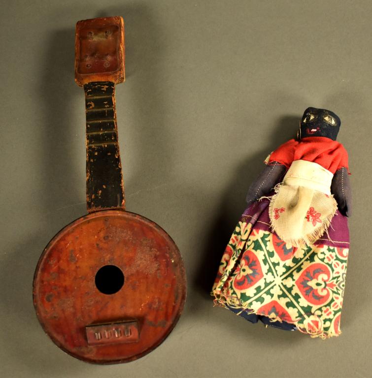 Primitive Doll and Mandolin Toys: Doll has been hand sewn and stuff with newspaper. Illegible writing on front of doll; legs have been replaced with modern material. Mandolin does not have strings, shows wear from age, some rust, made