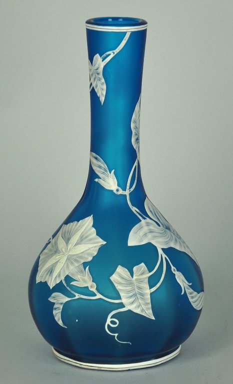 Blue & White Cameo Vase by Thomas Webb & Sons: Produced in Stourbridge, England, circa 1880's. Decorated with white florals, buds, and vines against a blue ground. Unsigned, but numbered 619/5 on its underside. 9" H. x 4 1/2" W.