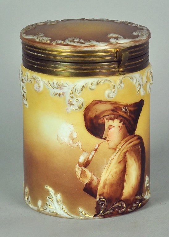 Hand-Painted Art Glass Tobacco Humidor: Decorated by Handel and Company. Depicts an image of a man in period dress, smoking a pipe. Decorated around its perimeter with the characteristic raised scrolls. The Handel factory was located in Mer