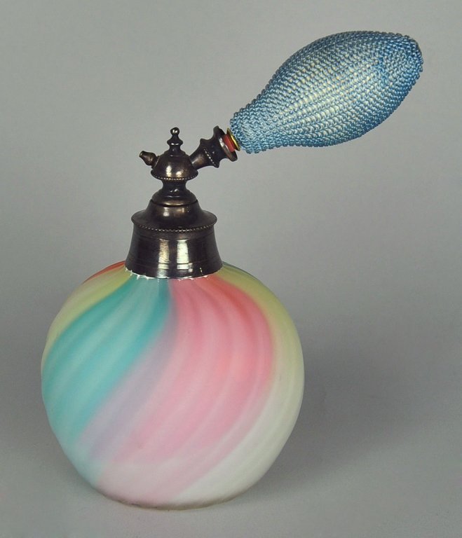 English Victorian Atomizer by Thomas Webb & Sons: Produced in rainbow colors shading from blue to peach to yellow. Molded swirl design. 5 1/4" H. x 3 1/4" W.