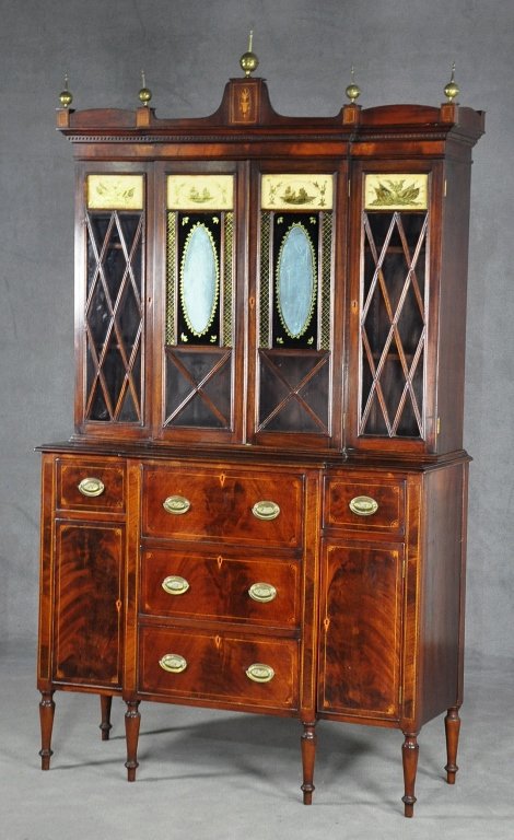 English Regency Mahogany Secretary: With writing desk. Federal style inlaid pediment. with brass ball and steeple finials, above four glazed and eglomise doors. Line and fan inlay. Lower section with pull out writing surface above two d
