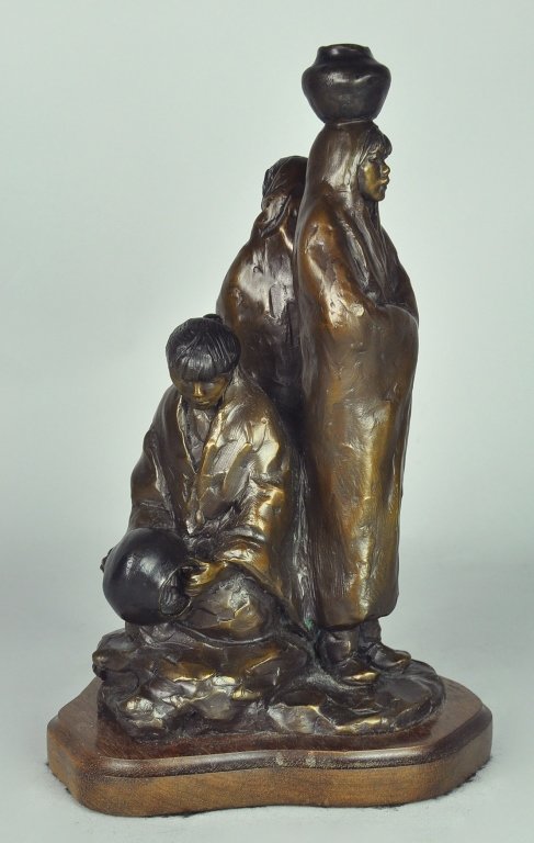 Glenna Goodacre "Water Carriers" Bronze: American - b. 1939. Depicting three Native American women, two standing and one seated, wrapped in blankets and each with a water pot. Marked, "G. Goodacre/1992 ©" and "35/99." Bronze, 11 3/4" H., on