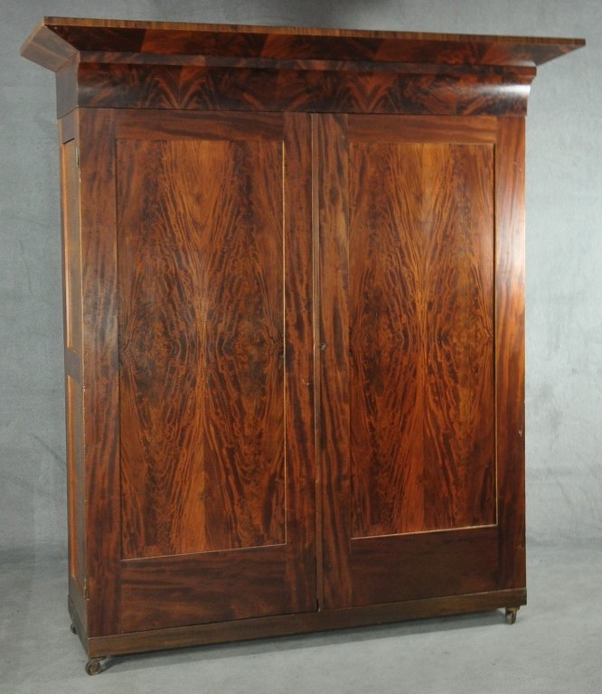 Mahogany & Burl Veneer Armoire: Mid 19th century, old refinish. Heavy cavetto cornice, above two paneled doors enclosing hanging compartments and drawers. Of knock-down form of six pieces. 84" x 74" x 28 1/2".