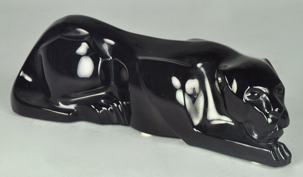 Baccarat Sculpture of a Panther: Smooth black surface. Panther in lying position. Etched with the Baccarat circular logo on the front right paw. 10" L.