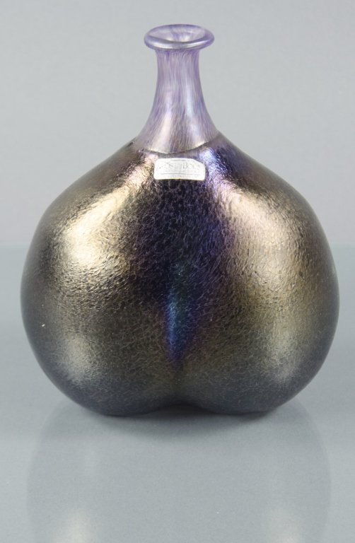 Swedish Bottle Vase by Kosta Boda: Iridescent purple bulbous body. Designed by Bertil Vallien. Original silver foil label reads "Kosta Boda/Kosta Boda, AB, Sweden/Handmade." The notation "Kosta Boda/Artist Cut/B.Vallien/48137." 3/4" H.