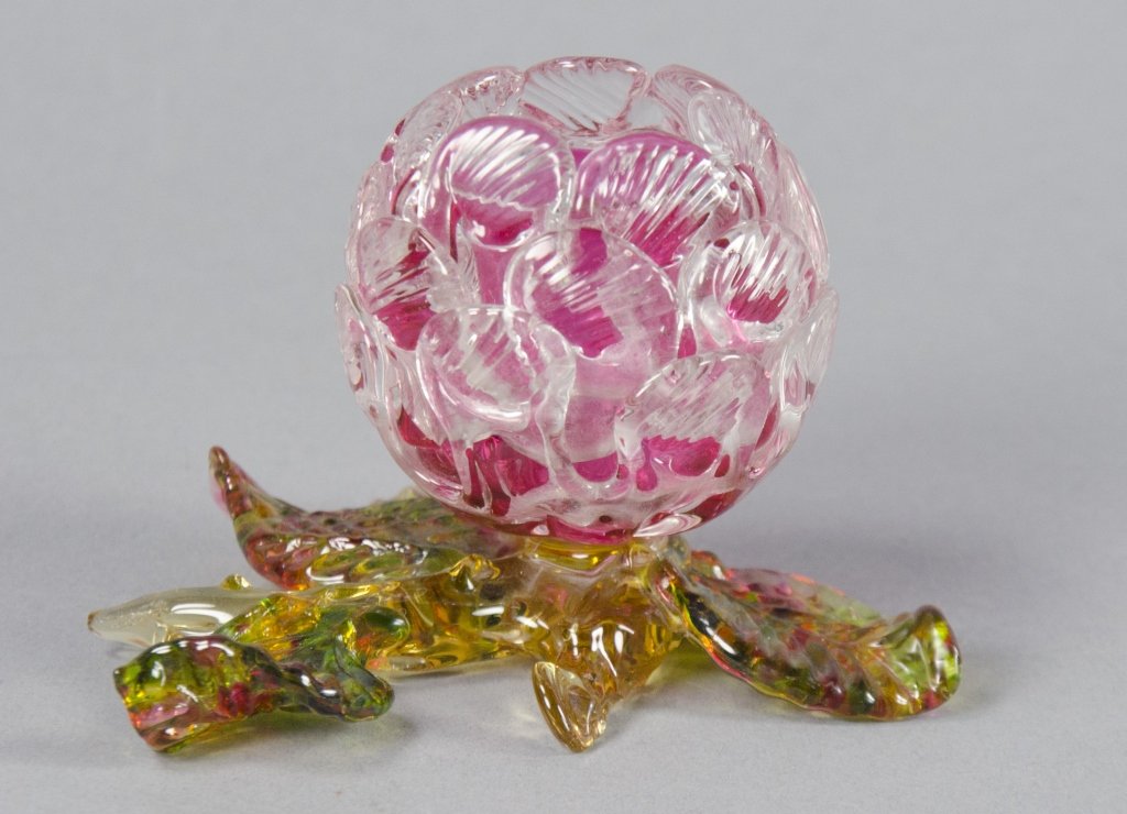 Cranberry Toothpick Holder: Clear glass exterior layered on cranberry interior. Sits on variegated polychromatic leaf and stem base. 2 3/4 H. x 4" L.