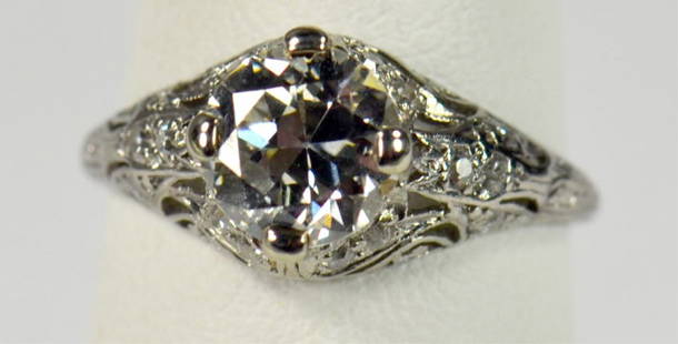 Platinum Diamond Solitaire Ring: Circa 1920's-40's, Art Deco style mount. Mounting with 16 older single-cut diamonds, .16 cts, SI, GH. Larger center European cut diamond. 7.15mm to 7.08mm. Approx. 1.45 cts, J, SI-1. Moderately abrade